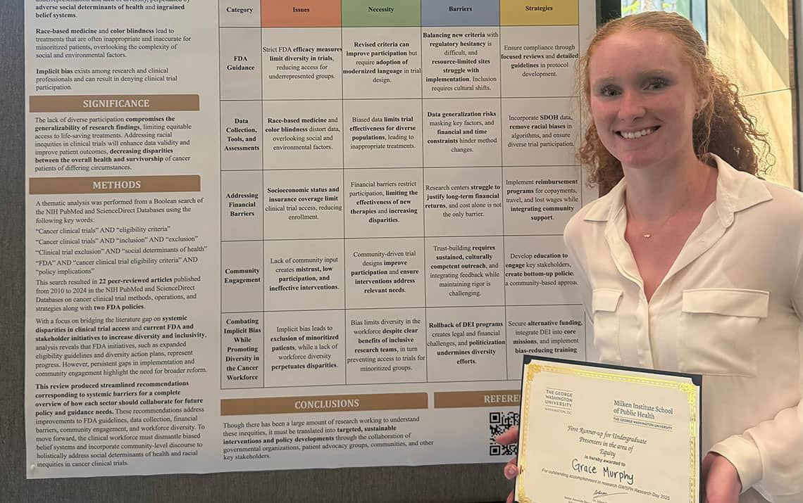 Grace Murphy standing with the 2nd place undergraduate equity prize and her presentation poster